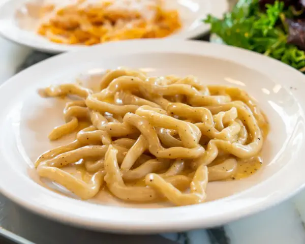 Pici cacio e pepe, un classico da provare a Siena. Pasta fresca condita con formaggio e pepe nero.