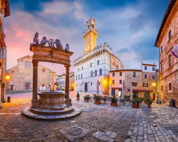 Piazza del Popolo, cuore del centro storico di Arezzo, con la sua fontana rinascimentale e il Palazzo Comunale illuminato al tramonto.