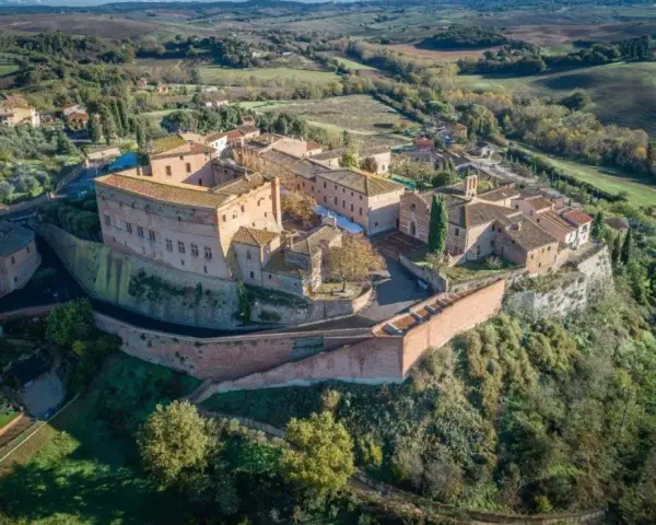 Borgo medievale di S. Giovanni d'Asso, con il suo imponente castello e le case in pietra, domina le dolci colline toscane.