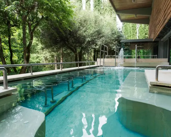 Piscina termale con cascata e alberi circostanti: un'oasi di relax da scoprire tra le cose da vedere a Chianciano Terme.