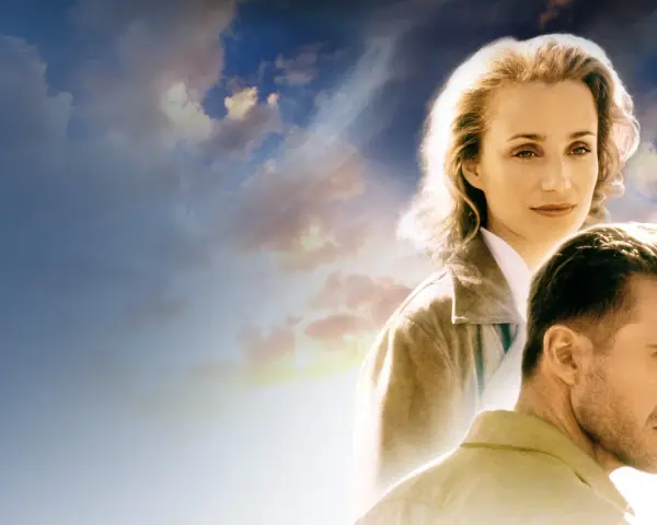 Volti di Kristin Scott Thomas e Ralph Fiennes sotto un cielo nuvoloso, evocano l'atmosfera de "Il Paziente Inglese".