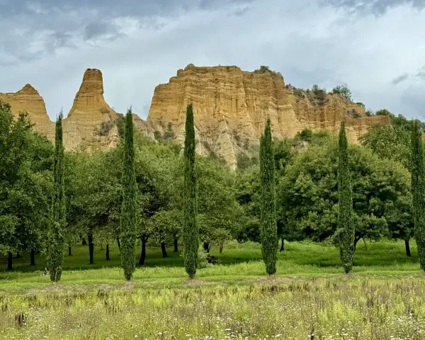 Paesaggio con calanchi ocra e cipressi slanciati, un invito a percorrere il sentiero dell'acqua zolfina.