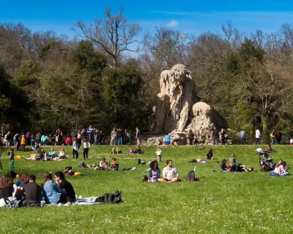 Pratolino: cosa vedere? La statua del Colosso dell'Appennino domina un prato verde affollato di persone che si godono il sole.