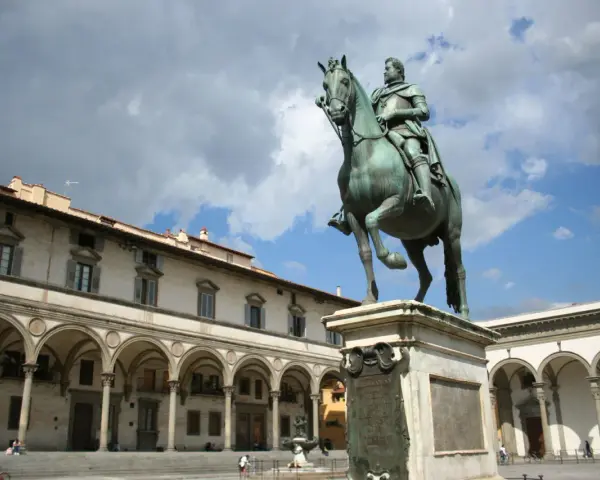 Statua equestre nella piazza della Santissima Annunziata, Firenze. Edifici storici con portici sullo sfondo.