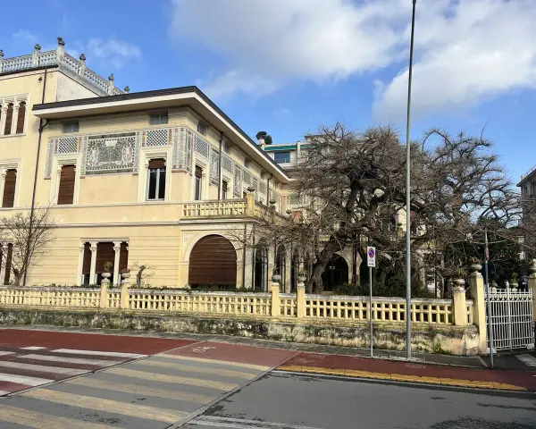 Villa Argentina a Viareggio, con la sua facciata decorata e un grande albero spoglio.