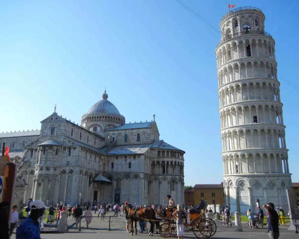 Piazza dei Miracoli a Pisa: la Torre Pendente, il Duomo e una carrozza trainata da cavalli. Ideale per scoprire cosa fare a Pisa.