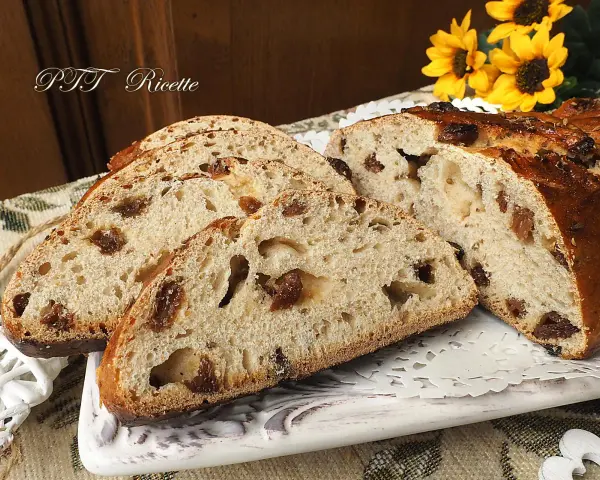 Fette di buccellato lucchese, un dolce tradizionale con uvetta e canditi, su un piatto decorato.