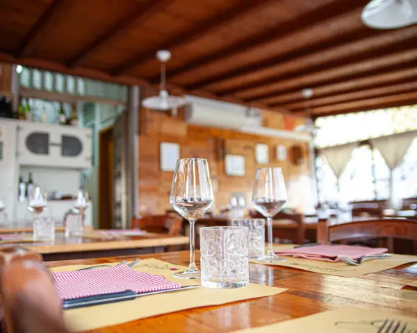 Tavoli apparecchiati in un'osteria ad Arezzo e dintorni, pronti per accogliere i commensali.