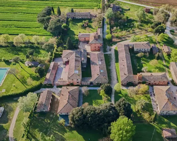 Un complesso rurale con piscina e campi verdi, tipico della campagna di Montagnano Arezzo.