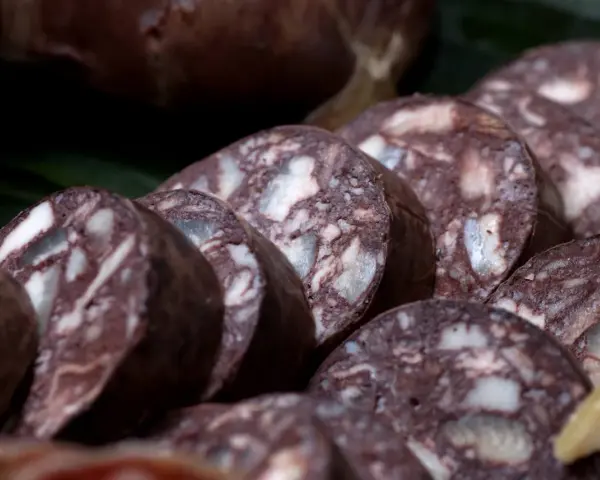 Fette di biroldo toscano, un salume scuro con striature bianche, pronto per essere gustato.