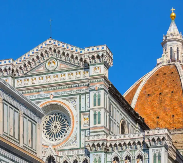 Dettagli architettonici del Duomo di Firenze, un must per chi visita Firenze cosa vedere. La cupola del Brunelleschi domina il cielo azzurro.