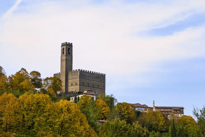 Castello medievale su una collina, circondato da alberi autunnali. Forse è qui dove hanno girato il ciclone.