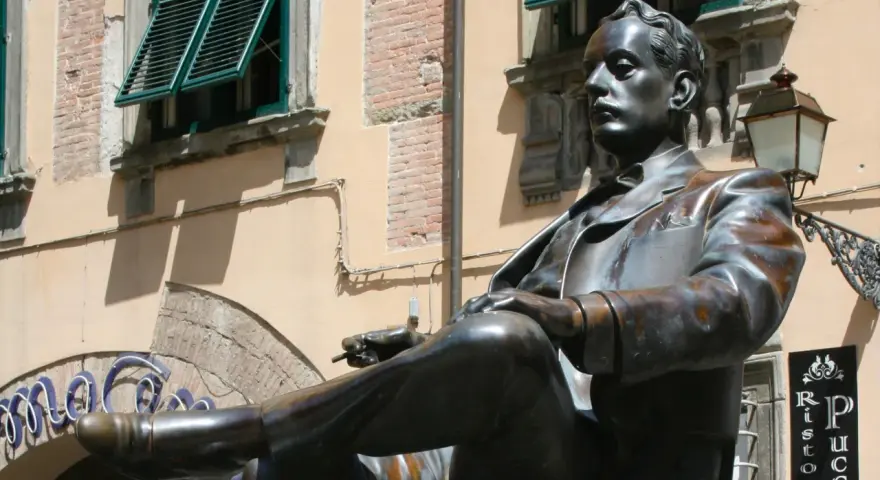 Statua di bronzo in piazza San Michele a Lucca, un uomo elegante con sigaretta.