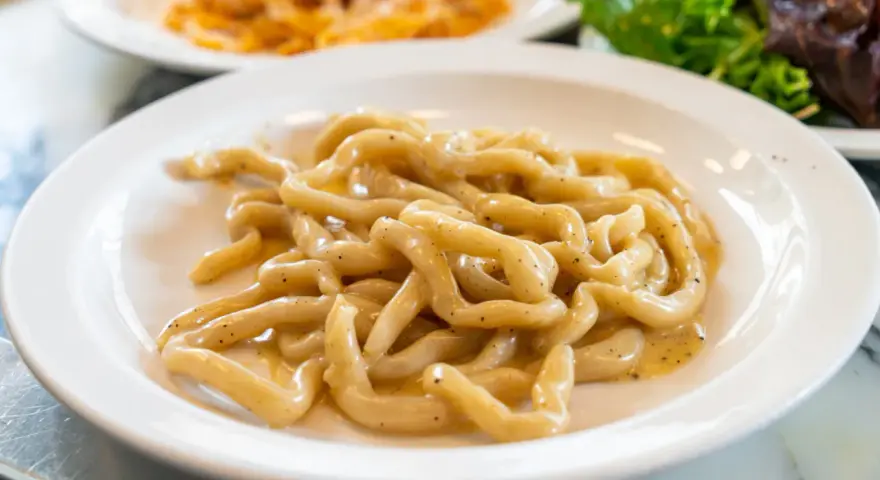 Pici cacio e pepe, un classico da provare a Siena. Pasta fresca condita con formaggio e pepe nero.