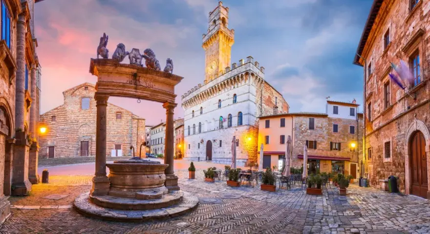 Piazza del Popolo, cuore del centro storico di Arezzo, con la sua fontana rinascimentale e il Palazzo Comunale illuminato al tramonto.