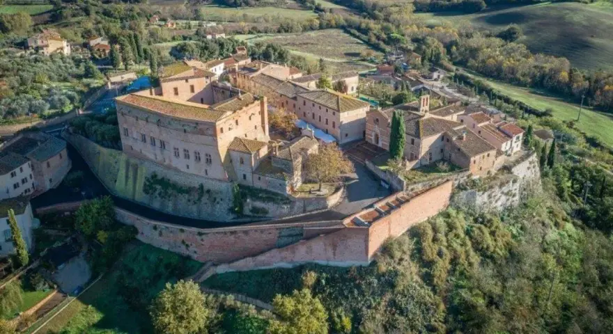 Borgo medievale di S. Giovanni d'Asso, con il suo imponente castello e le case in pietra, domina le dolci colline toscane.