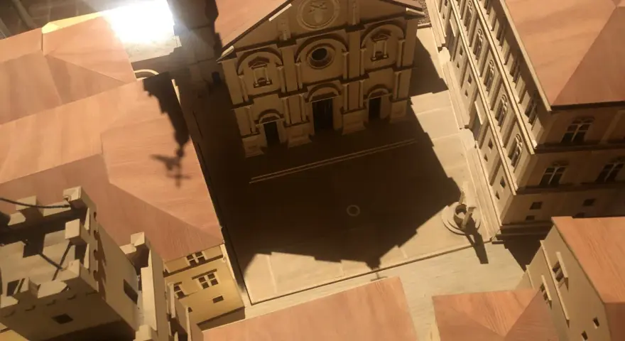 Modello in legno del duomo di Pienza e del suo complesso, con un'ombra a forma di croce che si proietta sulla piazza.
