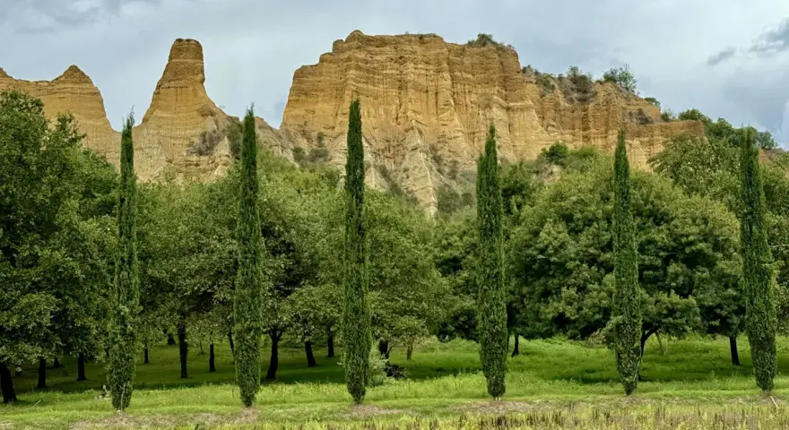 Paesaggio con calanchi ocra e cipressi slanciati, un invito a percorrere il sentiero dell'acqua zolfina.