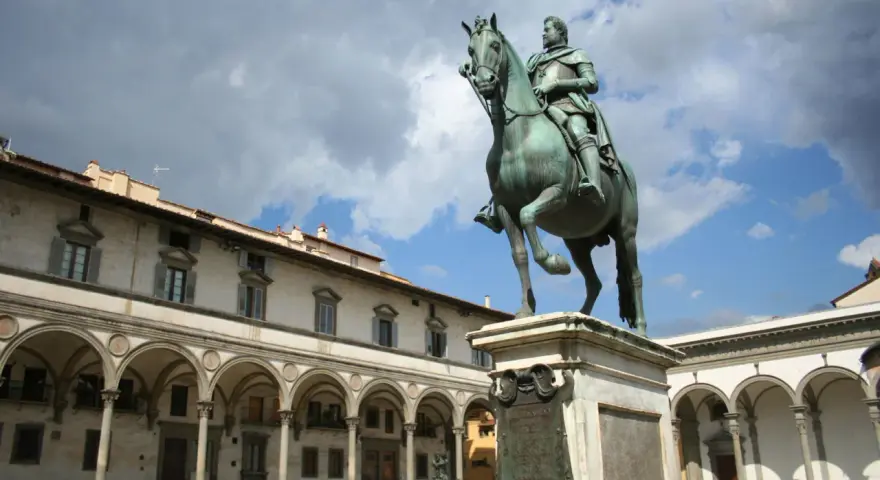 Statua equestre nella piazza della Santissima Annunziata, Firenze. Edifici storici con portici sullo sfondo.