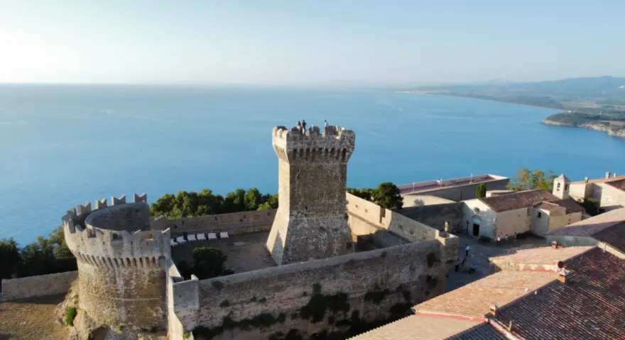Rocca di Populonia, uno dei luoghi imperdibili da vedere a Piombino, domina il mare blu.