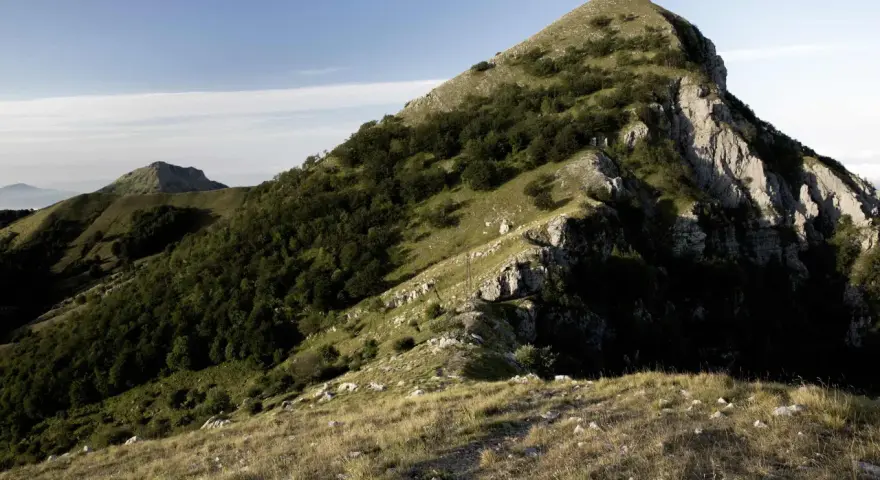 Panoramica del monte Matanna con pendii erbosi, rocce affioranti e boschi di faggi.
