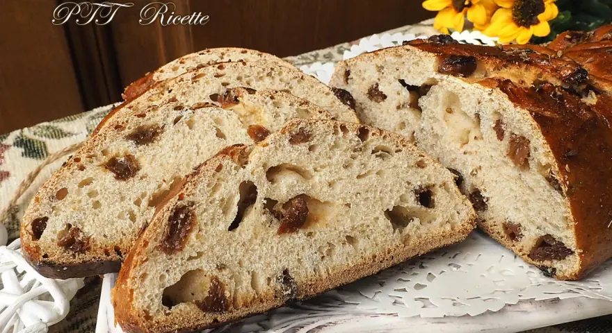 Fette di buccellato lucchese, un dolce tradizionale con uvetta e canditi, su un piatto decorato.
