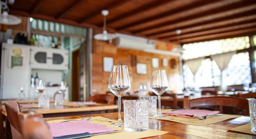Tavoli apparecchiati in un'osteria ad Arezzo e dintorni, pronti per accogliere i commensali.