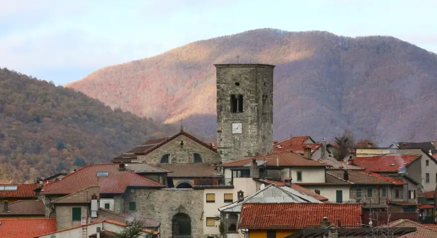 Torre medievale e tetti rossi a Careggine, un borgo incantevole da scoprire tra le montagne autunnali.