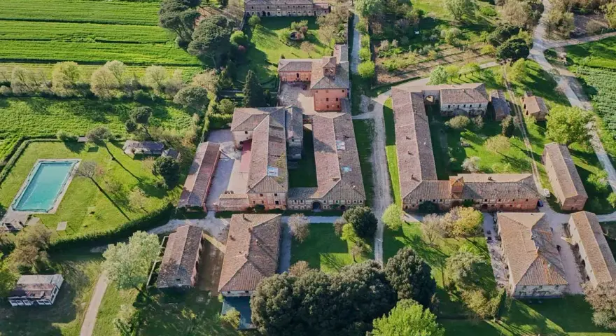 Un complesso rurale con piscina e campi verdi, tipico della campagna di Montagnano Arezzo.