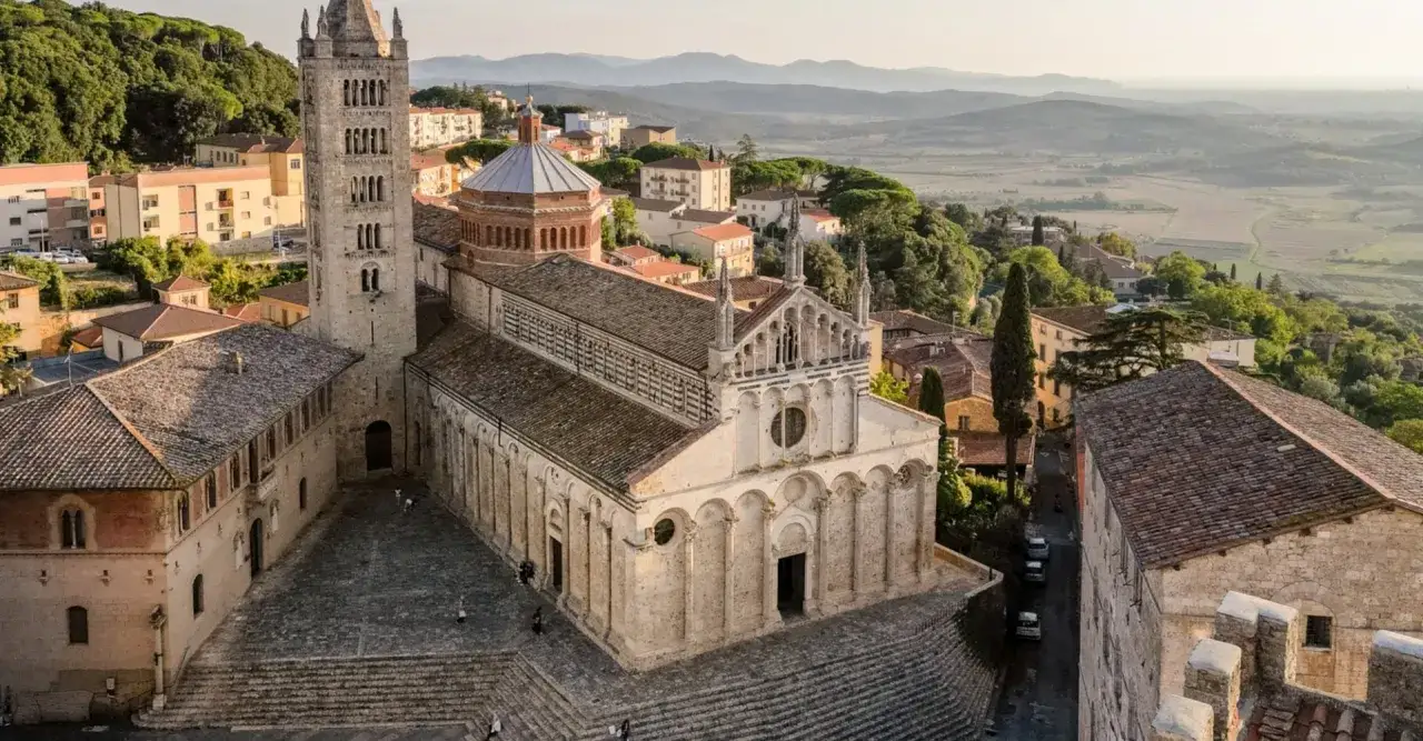 Vista aerea di Massa Marittima, con il Duomo romanico e il campanile che dominano il paesaggio collinare toscano.