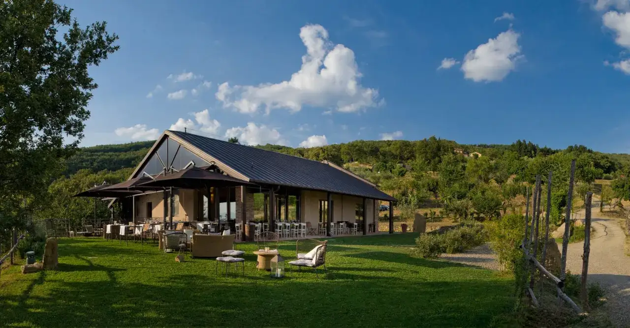 Il podere di pomaio, con il suo ristorante moderno e la terrazza verde, immerso tra le colline toscane.