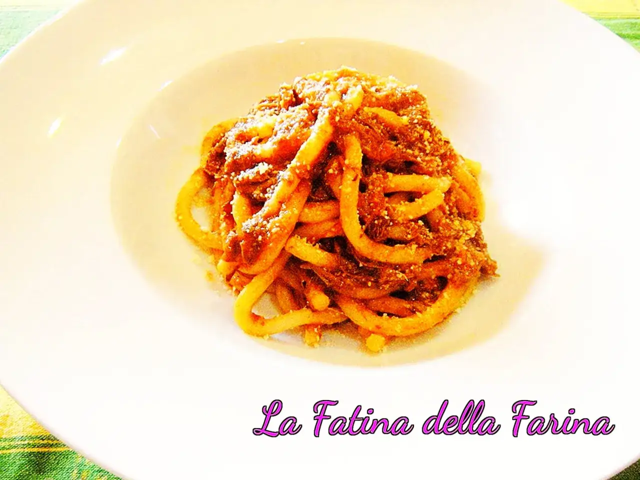 Pici alla nana, un piatto di pasta fatta in casa con un ricco sugo di carne, servito su un piatto bianco.
