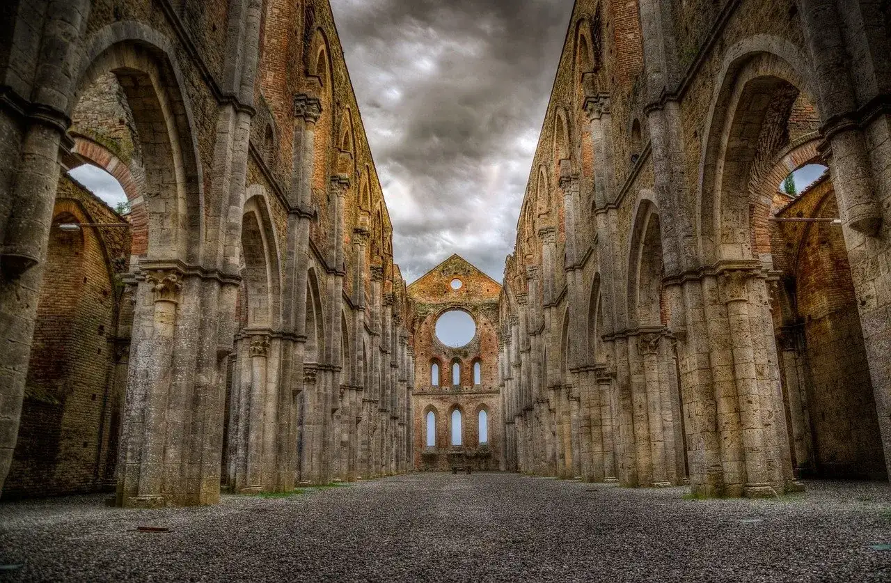 Le imponenti rovine dell'abbazia di San Galgano, con le sue arcate maestose e il cielo tempestoso, evocano un senso di storia e mistero.