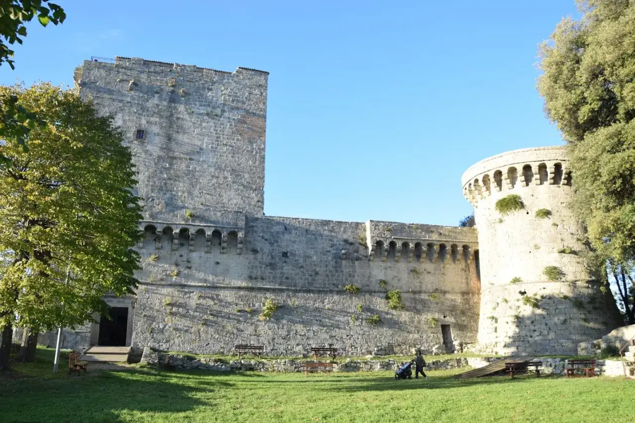 Rocca di Sarteano: cosa vedere. Imponente castello in pietra con torre circolare e mura merlate, un luogo storico da esplorare.