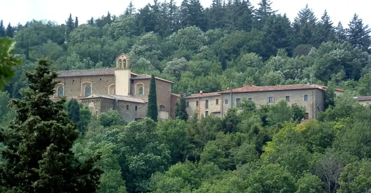 Antico complesso monastico immerso nel verde, con campanile e facciata in pietra, a Sargiano, Arezzo.