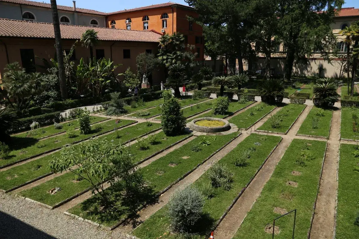 Il jardin botanique de Pise, con aiuole geometriche e una fontana centrale, è un'oasi di tranquillità tra antichi edifici.