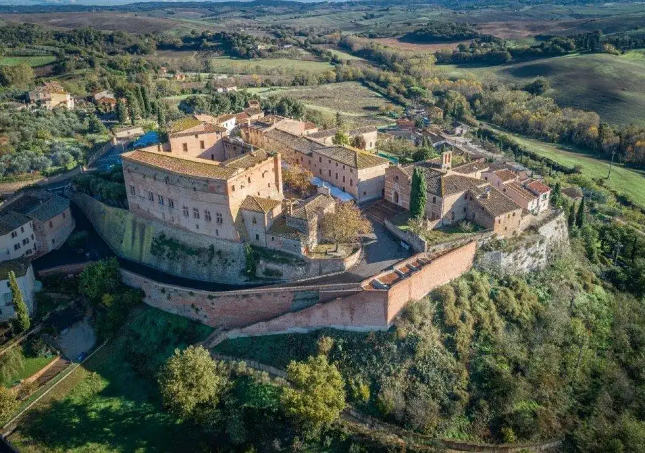 Borgo medievale di San Giovanni d'Asso, con il suo imponente castello e le case in pietra, domina le dolci colline toscane.
