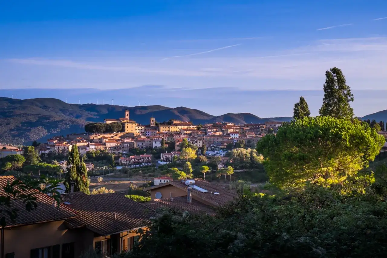 Panoramica di Montescudaio cosa vedere: borgo toscano con case in pietra, torri e colline verdi.
