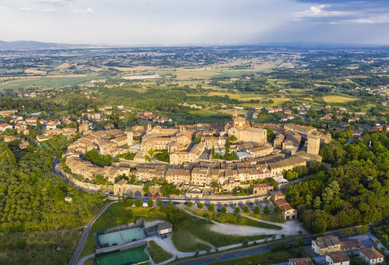 Borgo medievale di Lucignano, Arezzo, con le sue mura concentriche e la campagna toscana circostante.