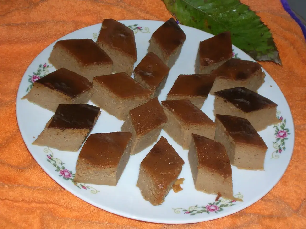 Fetta di tortelli di castagne di Marradi, un dolce tradizionale dal sapore autunnale, servito su un piatto decorato.