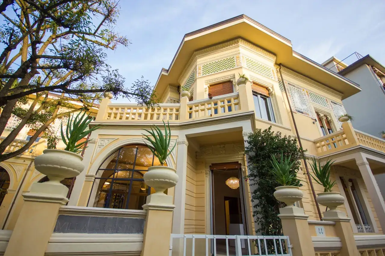 Villa Argentina a Viareggio, un'elegante dimora con decorazioni liberty, vasi con piante e un'atmosfera accogliente.