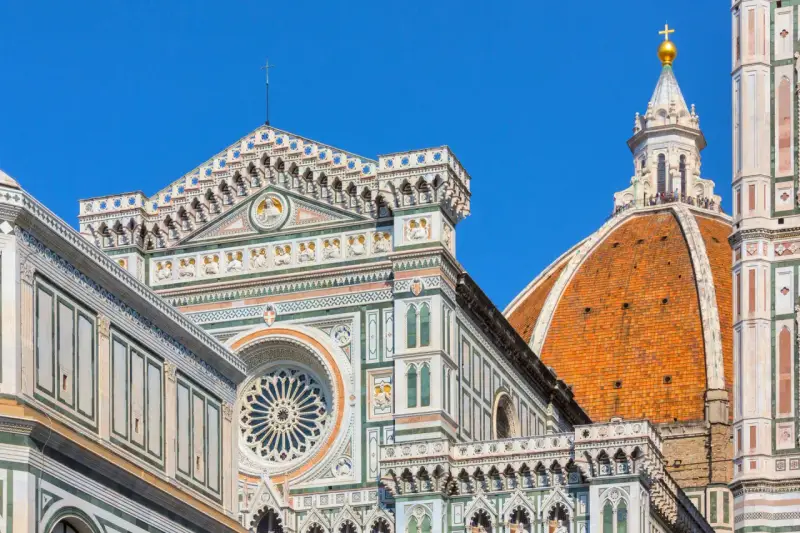 Dettagli architettonici del Duomo di Firenze, un must per chi visita Firenze cosa vedere. La cupola del Brunelleschi domina il cielo azzurro.
