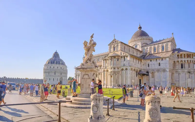 La piazza del Duomo a Pisa, con il Battistero, la Cattedrale e la celebre torre di Pisa, gremita di turisti.